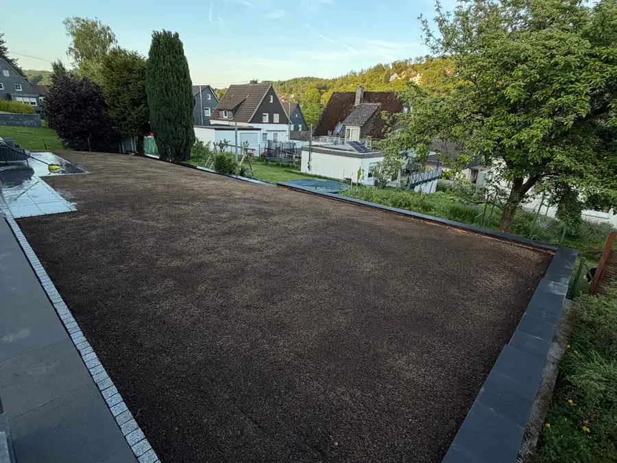 Fertig abgezogenes Planum mit Mutterboden und Granit-Randeinfassung